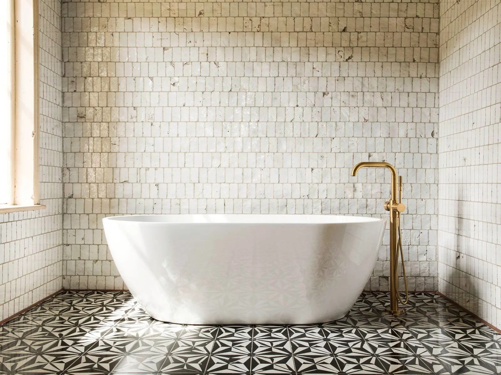 A bathroom with its terracotta floor replaced by black and white cement tiles, the walls unchanged, after